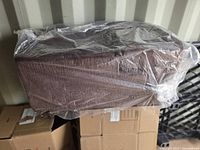 Two brown fabric pet stairs wrapped in plastic on top of boxes