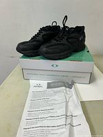 Pair of black Apex shoes on box with care sheet visible