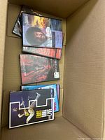 Open cardboard box showing several DVD cases including Bob Ross and others