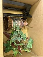 Box showing black wall shelf, clear glass globe, grapevine basket, artificial ivy and burgundy star