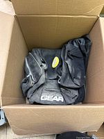 Box containing black Sno-X Gear bag showing logo