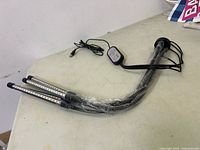 Full view of grow light showing three wrapped LED bars, flexible necks, clamp base, and USB cable