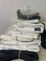Group of folded karate belts on table showing white and black colours