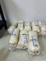 Eight sealed bags of white inspector gloves on table