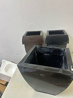 Three metal square planters grouped on table
