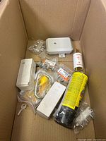 Overview of box contents showing junction box, aerosol can, lock cylinder, screws