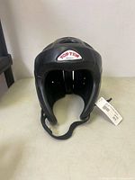 Front view of Top Ten headgear showing logo and chin strap