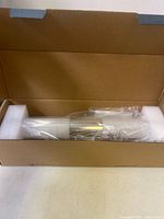 Light fixture in plastic wrap with foam supports inside box