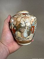 Front angled view of the vase showing hand-painted figures in traditional dress and detailed patterns