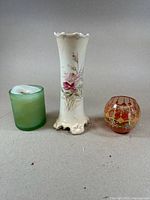 Three items side by side: green glass candle holder with white candle, Austrian porcelain vase, amber hand-blown Egyptian glass candle holder.