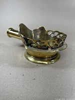 Side view showing the brass construction, large size, and perforated edge detail of the antique iron.