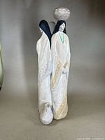 Front view of Austin Productions Navajo Woman statue showing full figure with pot on head, black hair, white robes with gold accents and turquoise necklace.