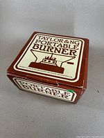 Box of Taylor & NG Portable Burner with brown and white bold text and a graphic showing the burner and pan setup.