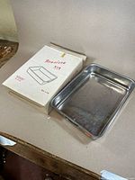 Photo of the Brasiera cooking tray next to the original box showing the tray's condition and packaging.