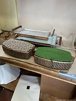 Group image showing four vintage Mid Century Modern hot trays on a wooden surface: two in front with fabric covers and two metal trays at the back with power cords.
