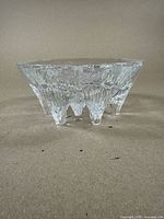 Full side view of the clear glass bowl showing textured glass and shape with feet