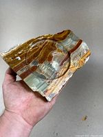 Close-up of the large polished onyx specimen showing natural banding and polished surface with a carved circular recess.