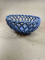 Side angled view of the large blue porcelain basket showing the woven lattice design and base shape.