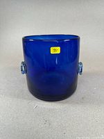 Cobalt blue glass ice bucket with rounded handles, showing front and side views.