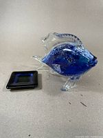 Murano glass fish sculpture in blue and clear glass next to the small square glass dish