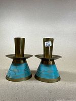 Pair of brass candle holders with blue decorative paint and etched patterns