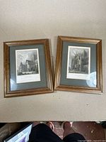 Overview of the pair of framed York Cathedral prints from 1838, showing wooden frames and gray mats.