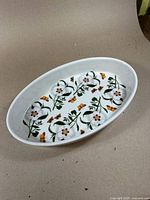 Oval porcelain baking dish showing full interior floral and butterfly pattern.