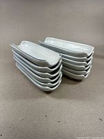 Stack of 12 corn cob-shaped stoneware pans showing the form and glaze of the set