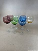 Front angled view of the seven colored balloon wine glasses showing variety of colors and shape