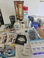 Full layout of lot showing majority of items including lotions, deodorant, false eyelashes, dental kits, hair treatment tubes and more