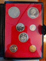 Open presentation case showing all seven coins in red flocked insert