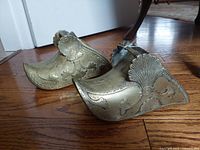 Pair of bronze stirrups side view showing decorative motifs