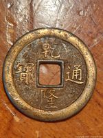 Front view of bronze coin showing characters and square hole