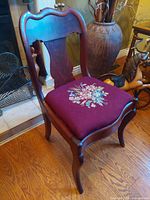 Full view of wood vanity chair positioned near fireplace