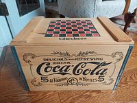 Front of wooden Coca-Cola toy chest showing vintage graphics