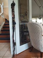 Full view of walking stick leaning against door