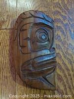 Oblique view of carved wooden face plaque