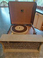 Portable RCA Victor record player open showing platter, tonearm, hinged lid