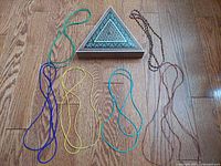 Group shot showing triangular inlaid box and six necklaces laid out