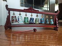 Front view of hardwood stand with eight cloisonné bells and striker