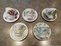 All five cup and saucer sets displayed