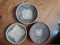 Three round woven baskets displayed on wood floor
