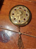 Front view of compact showing Cleopatra motif and rhinestones