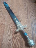 Full view of sword front, showing blade and ornate hilt