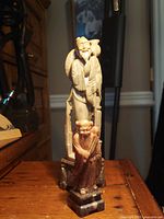 Front view of both stone figurines showing size relation and bases