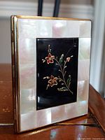 Front view showing mother of pearl border and floral enamel center