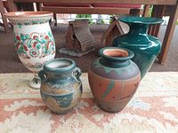 Group shot of five teal-themed pottery vases