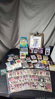 Overall lot showing sealed pack box, autographed photo, card stacks, sleeves