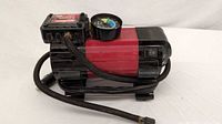 Full view of MotoMaster 12V air compressor with hose and power cord