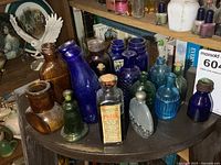 Group of assorted antique bottles on round shelf